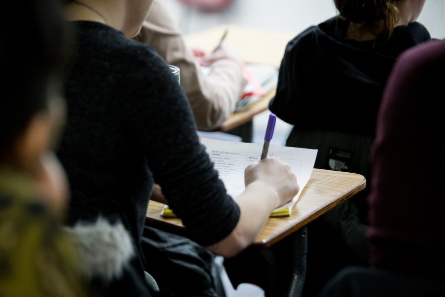 student writing on paper in uw-madison Certificate Course
